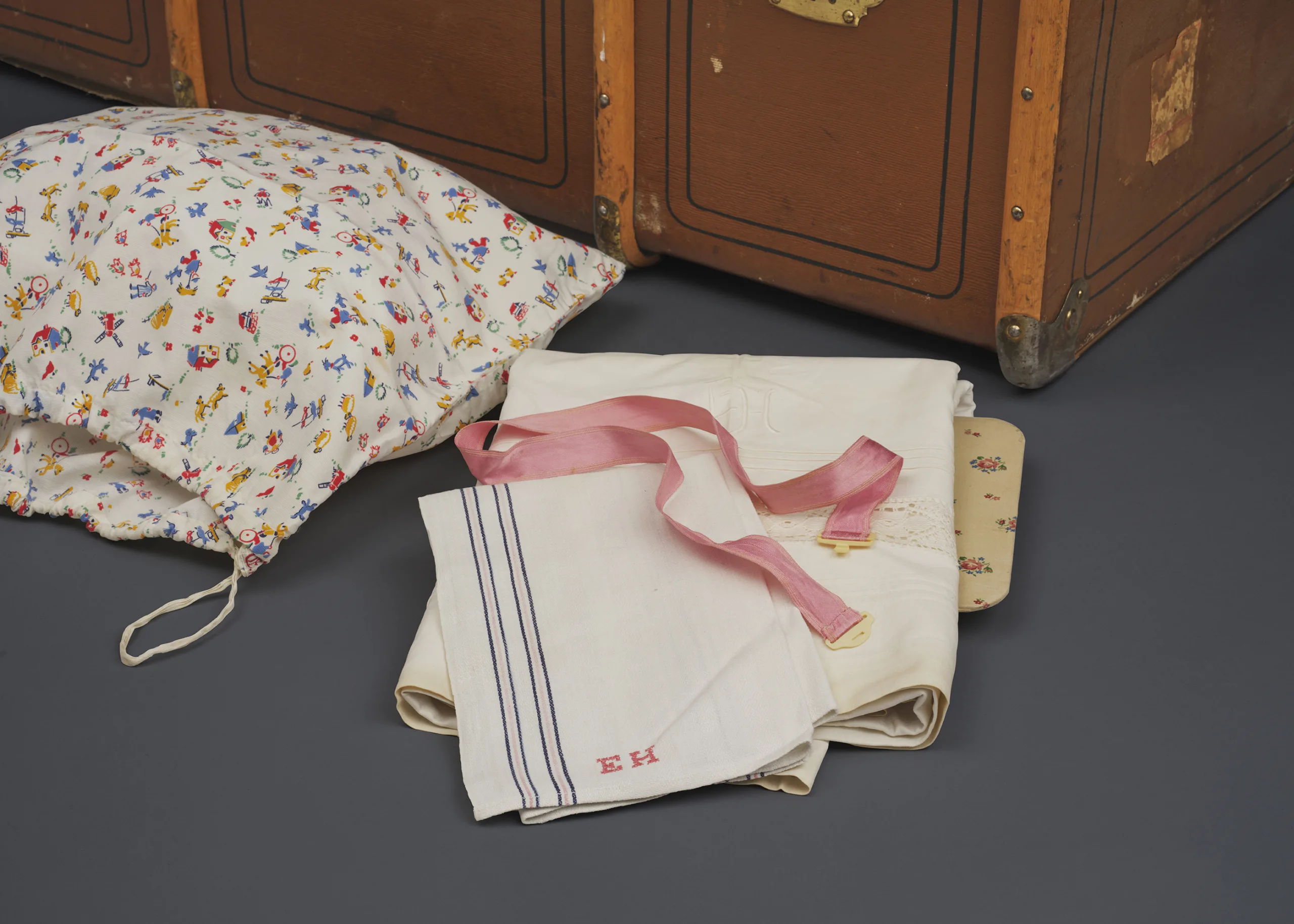 Föremål från museets samling, bland annat lakan och en tvättpåse.