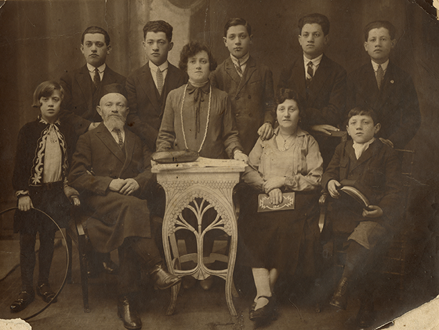 Old yellowed portrait photography. Nine people can be seen in the picture.