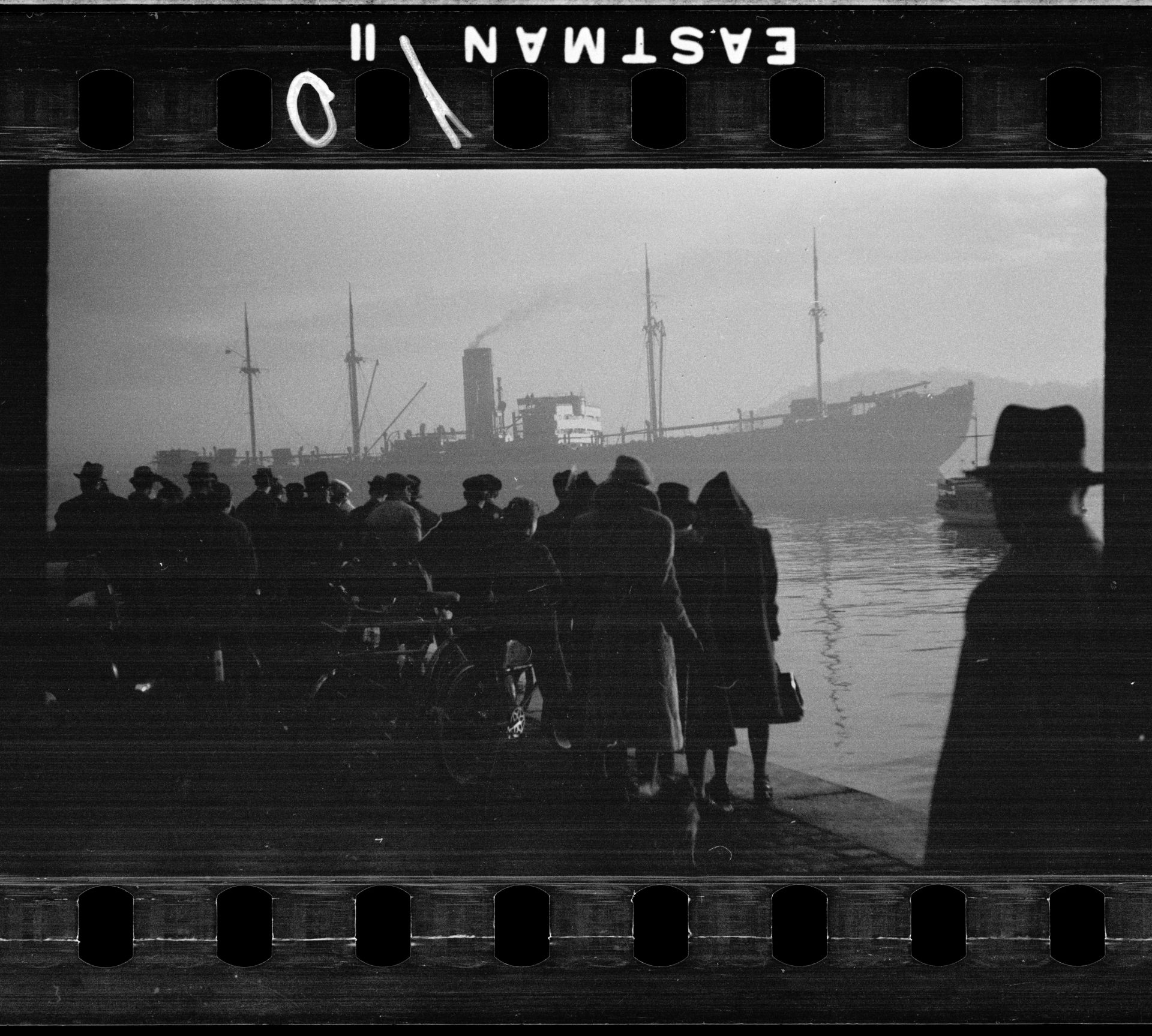 I förgrunden en grupp människor och i bakgrunden syns det nazityska skeppet SS Donau i Oslo hamn 1942.