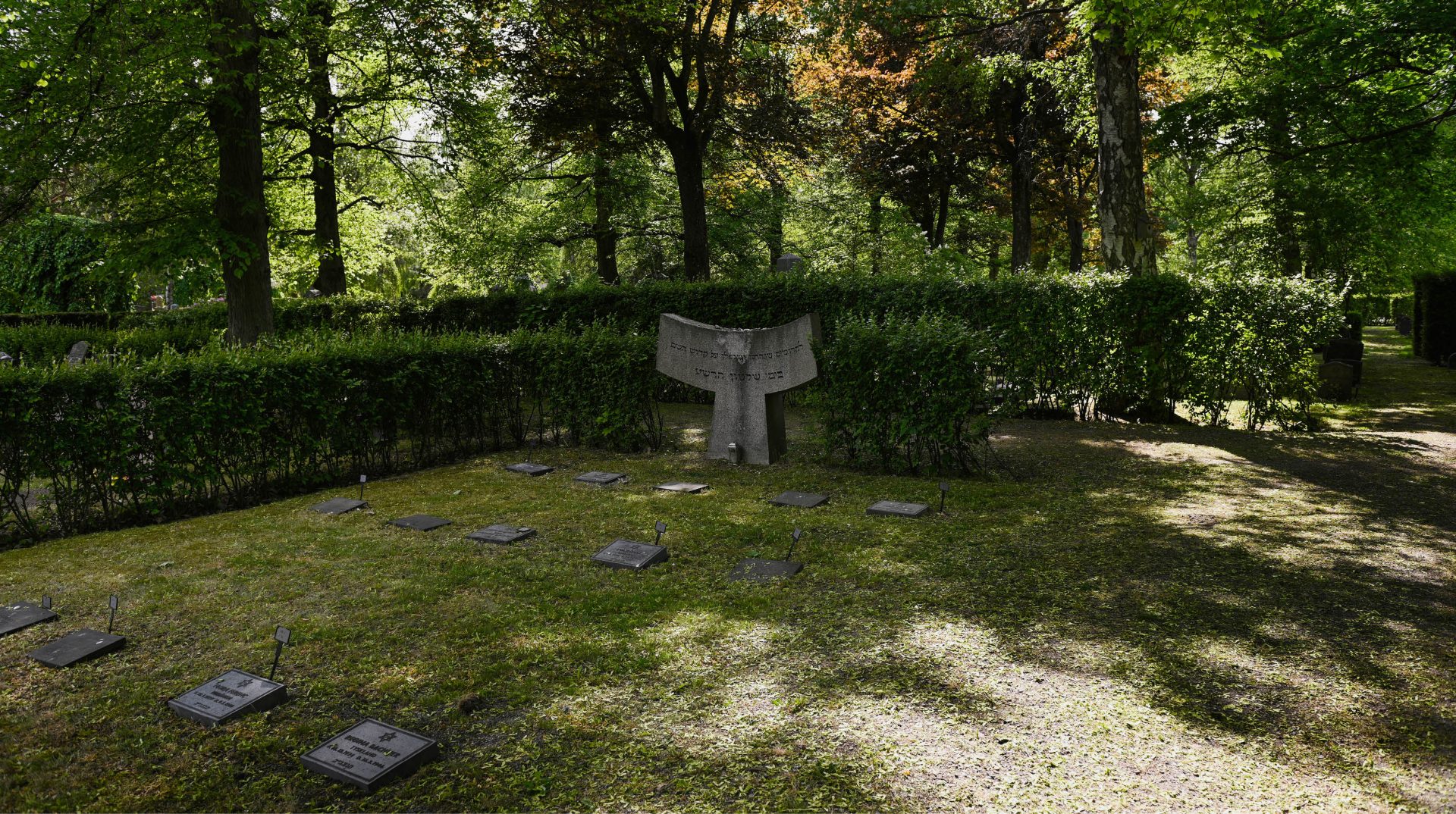 Norra judiska begravningsplatsen där gravstenar syns i förgrunden och i bakgrunden träd