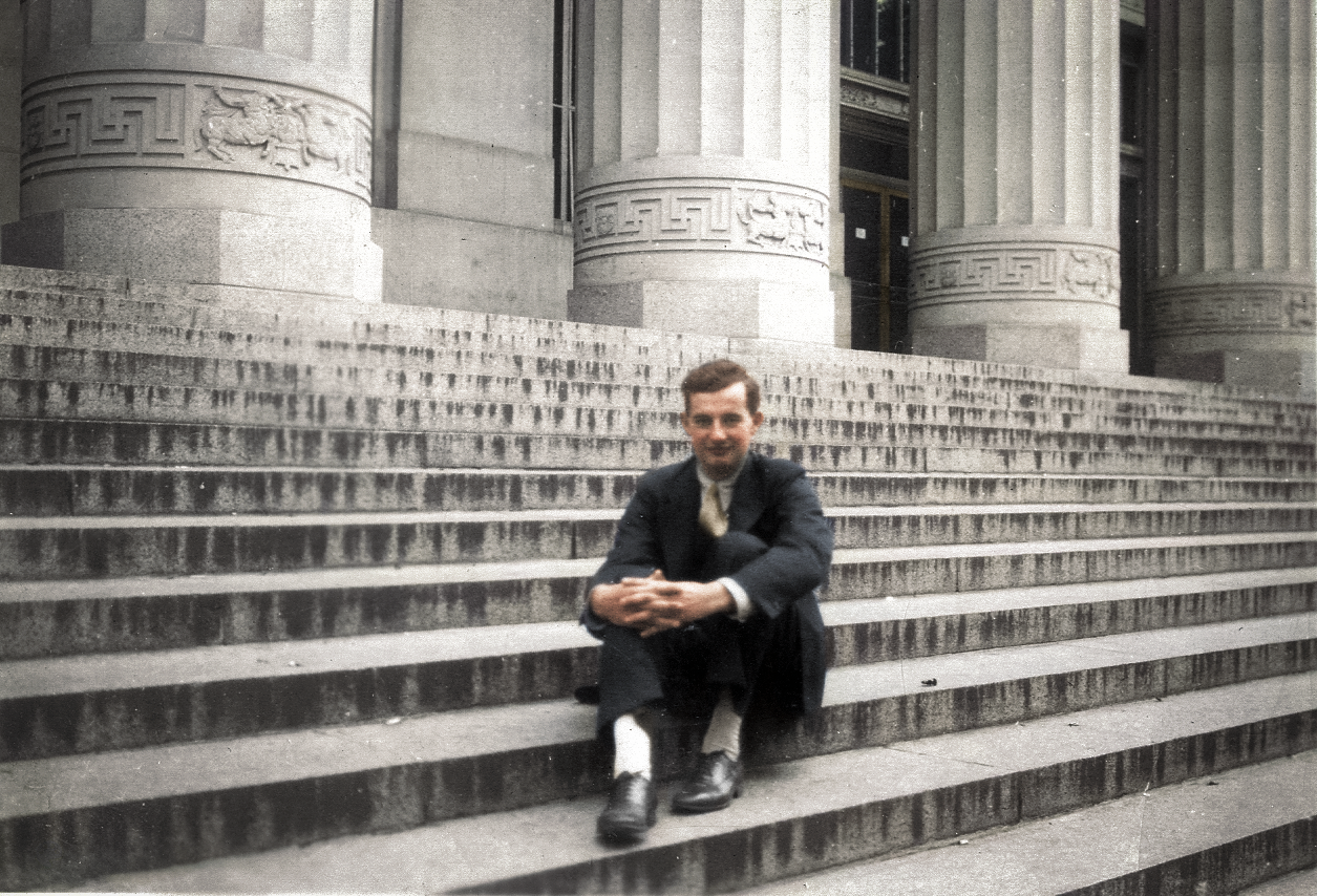 Kolorerad bild på Raoul Wallenberg sittandes i en trappa.