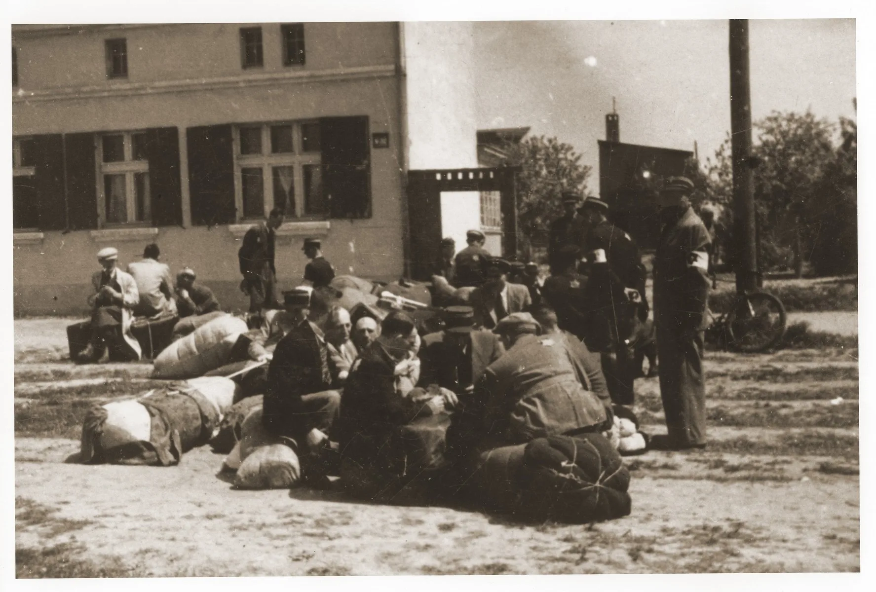 Jewish police guard a group of central European Jews who have been assembled for deportation in the central prison of the Lodz ghetto.