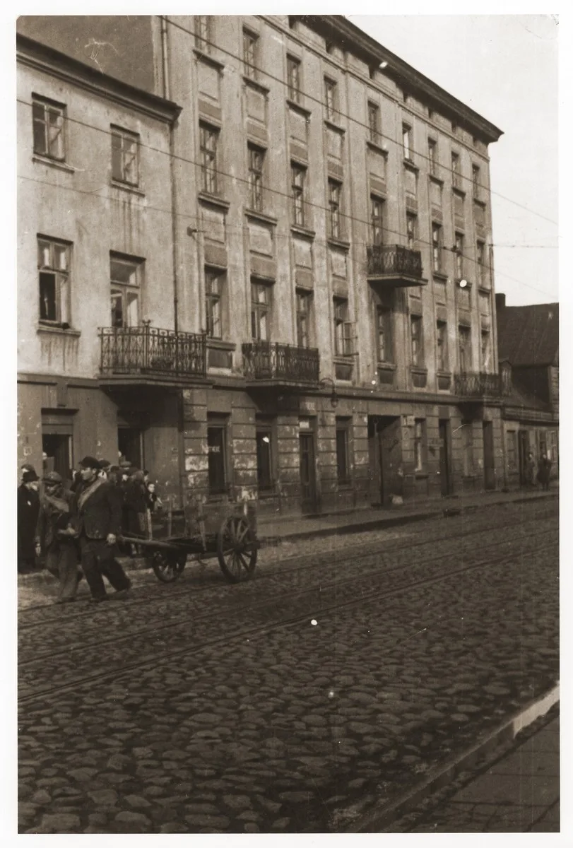 Street scene in the Lodz ghetto with two men pulling a cart.