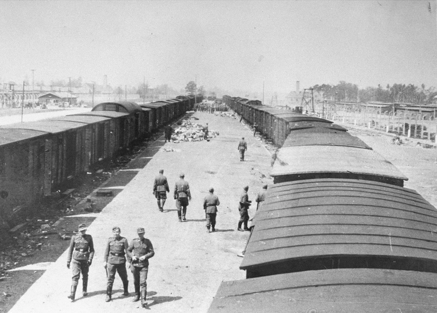 SS guards walk along the arrival ramp at Auschwitz-Birkenau.-yad-vashem