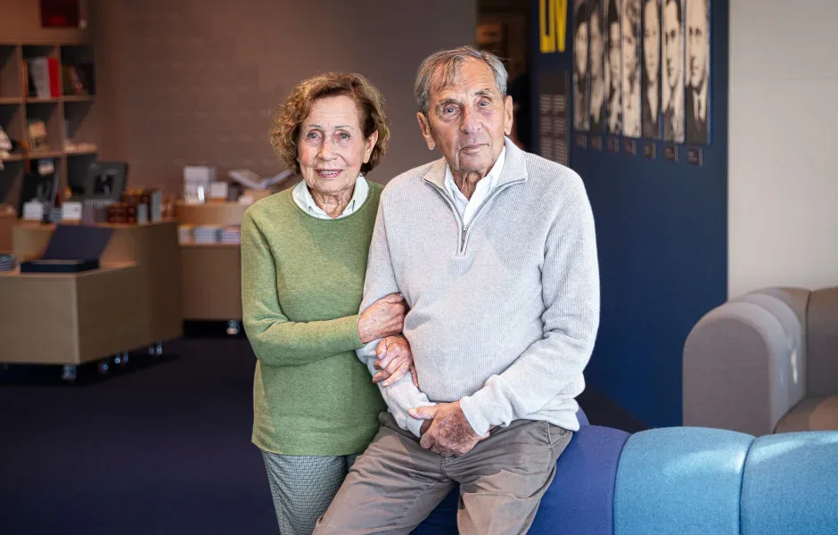 Porträtt på Dina och Jovan bredvid varandra med museibutiken i bakgrunden.
