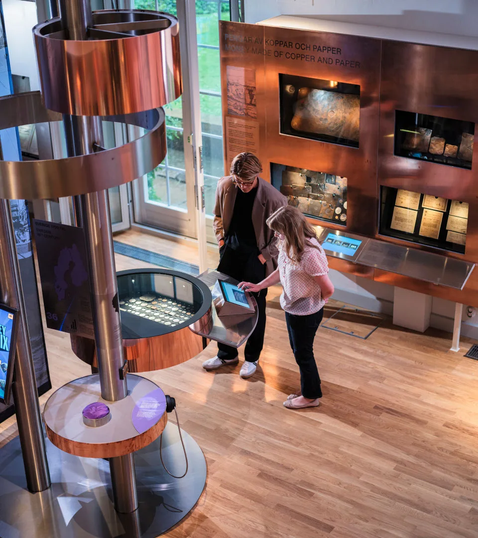 People look at coins in an exhibition