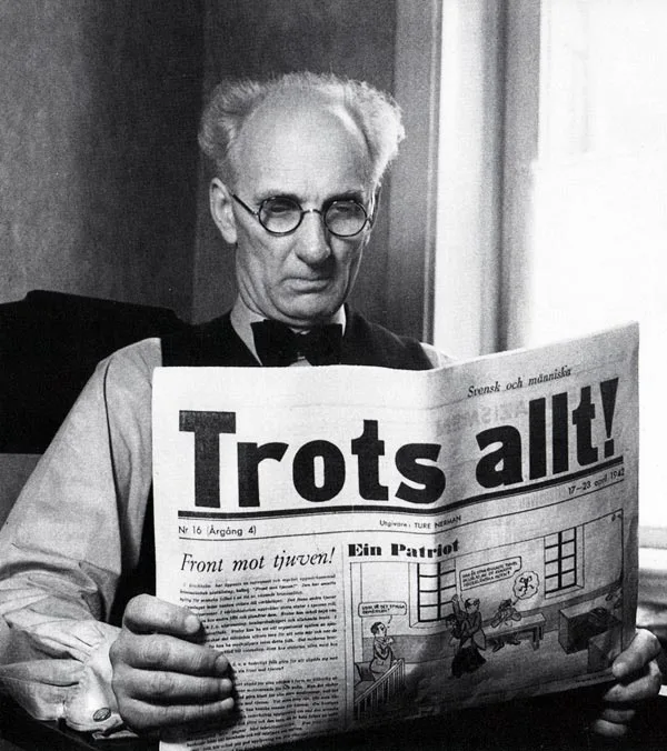 En man som sitter och läser en dagstidning.