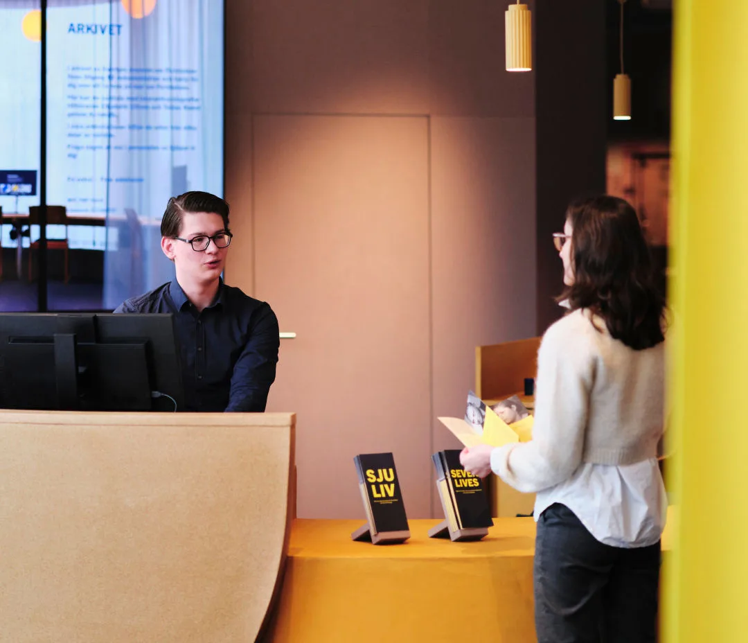 Besökare samtalar med en värd vid entrén.