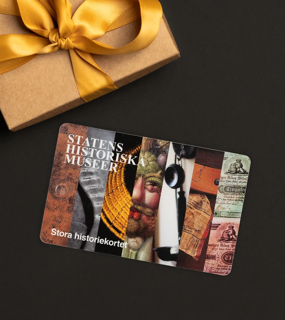 Framsidan av årskortet. Bilder från alla sju museer. I hörnet syns ett paket med rosett.