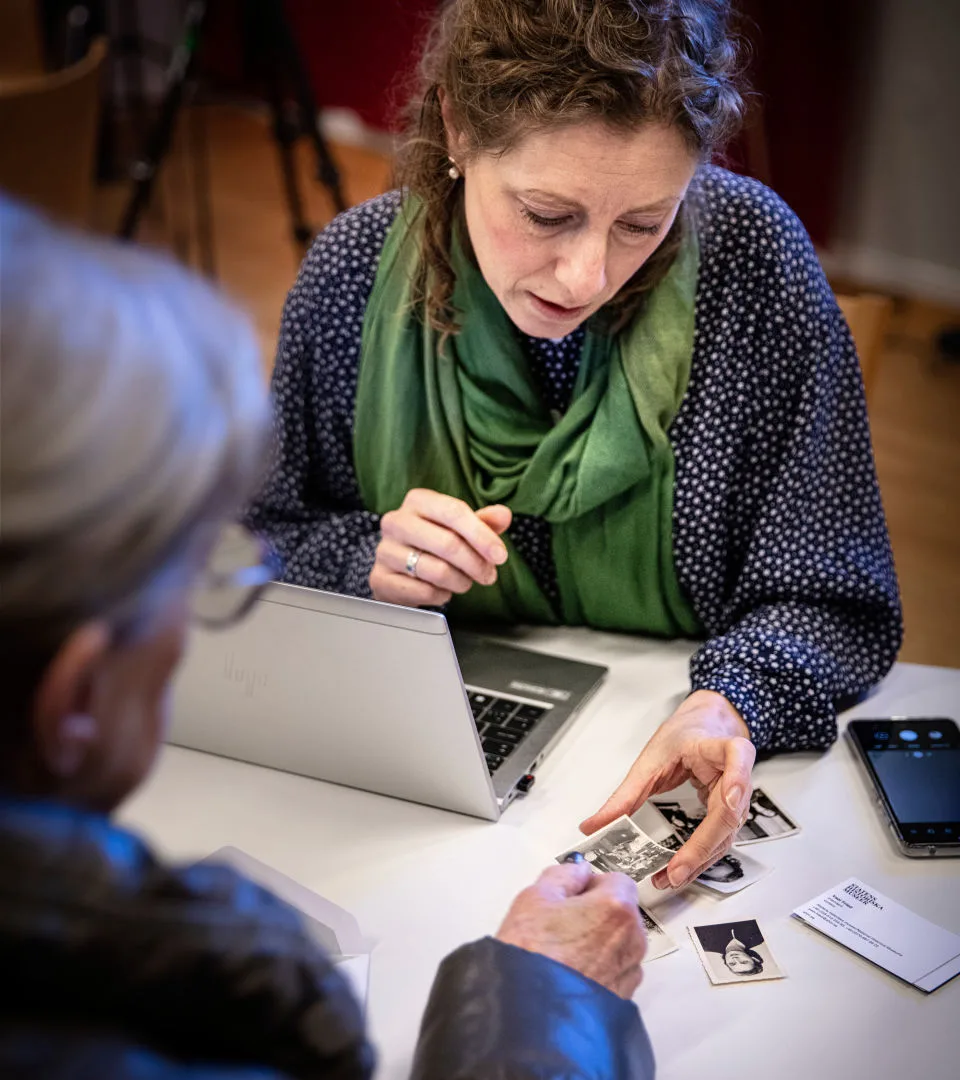 Museum staff looking at photographs together with a donor.
