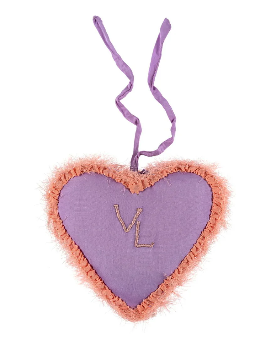 Lila hjärta i tyg med bokstäverna V och L broderade på framsidan.