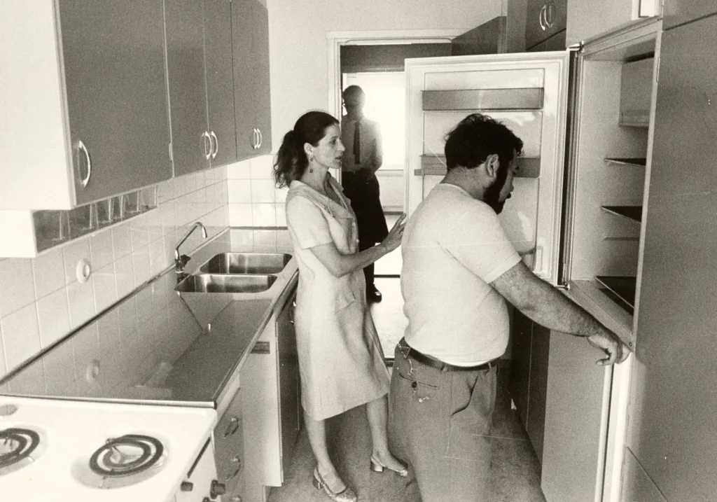 Nina and Franciszek Kwiek looking inside a refrigerator in their kitchen.